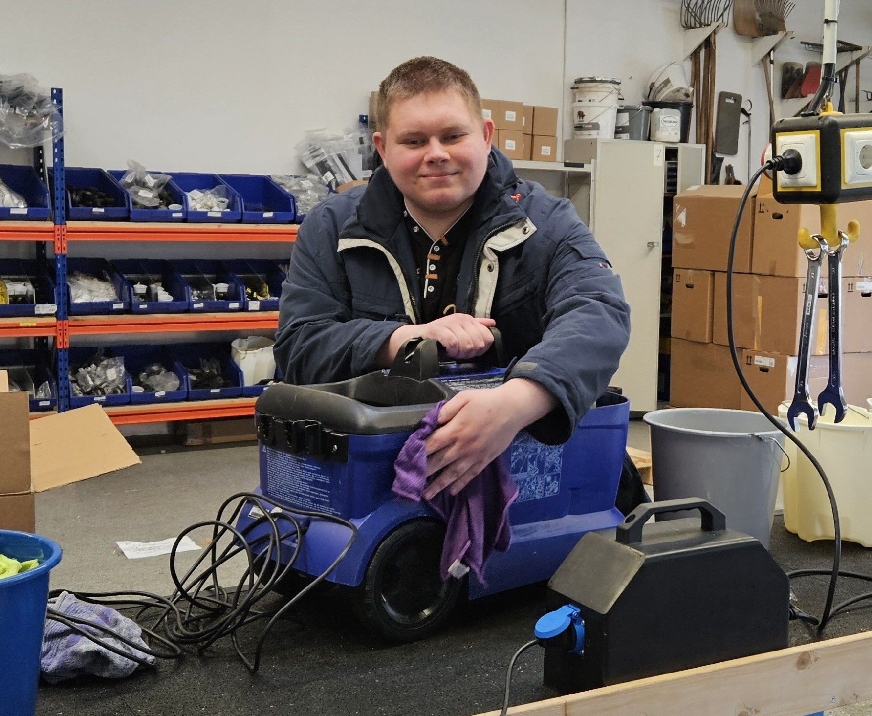 Ein Mitarbeiter reinigt einen Nasssauger.