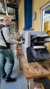 Die neue Kuvertiermaschine kann Anschreiben und Flyer falten, in Briefumschläge stecken und zukleben. Foto: Tameer Eden